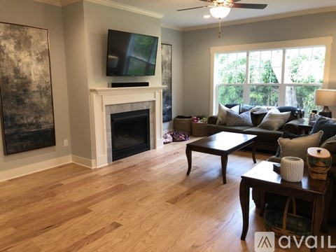 A living room with a fireplace and a television on the wall.