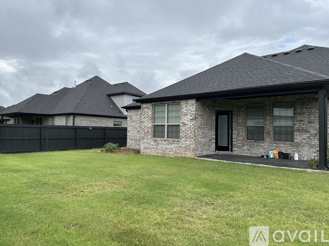 A house with a black roof and a grey stone exterior is shown.
