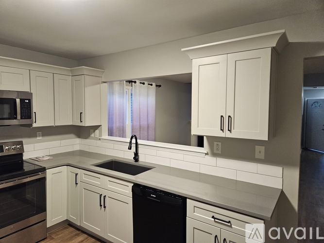 A kitchen with white cabinets and appliances.