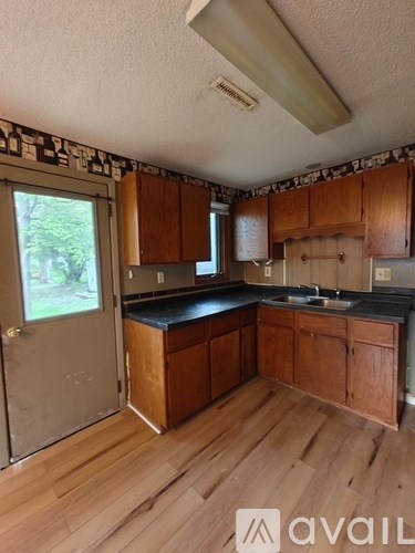 A kitchen with wooden cabinets and a black countertop.