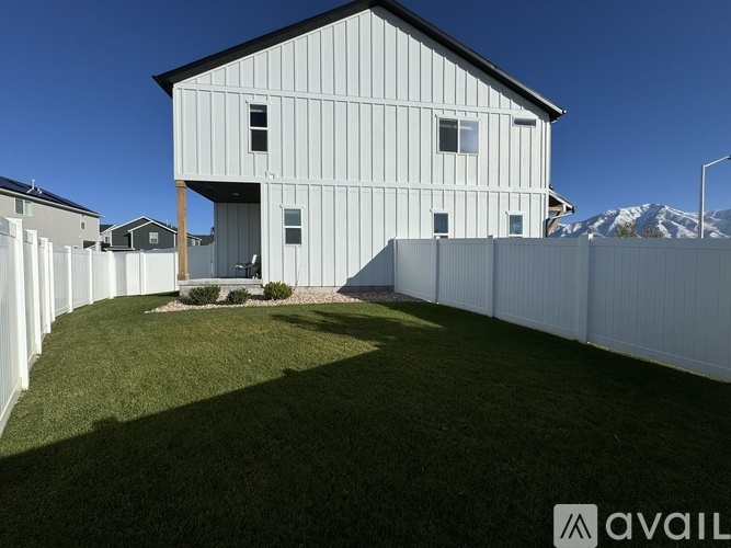 A modern house with a white exterior and a large yard.