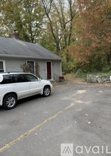 A white car is parked in a driveway.