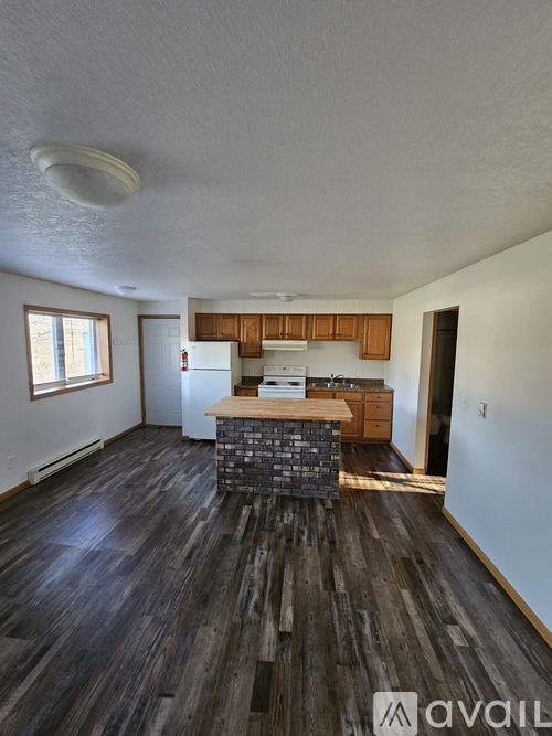 A kitchen with wooden floors and a white ceiling.