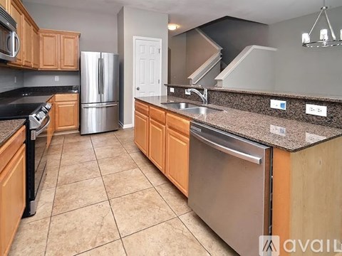 A kitchen with wooden cabinets and a granite countertop.