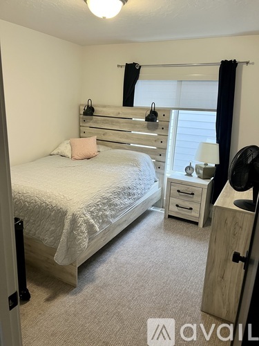 A bedroom with a bed, dresser, and nightstand.