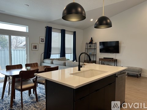 A kitchen with a table and chairs and a television.