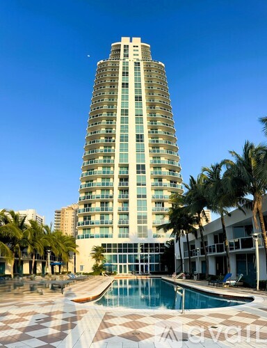 A tall building with a pool in front of it.