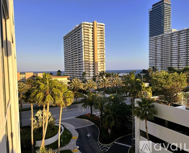 A view of a cityscape with palm trees and buildings.