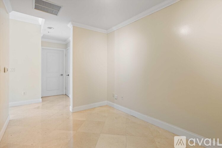 A spacious room with beige walls and a tiled floor.