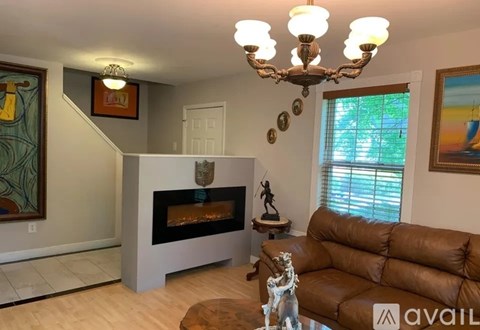 A living room with a brown couch and a fireplace.