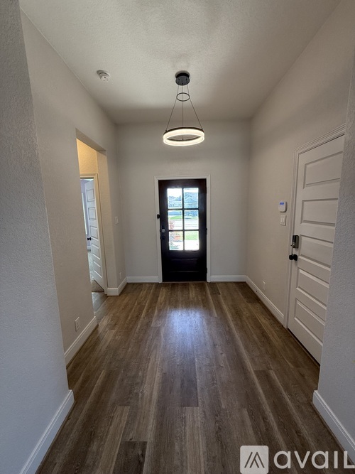 A hallway with wooden floors and a white ceiling.