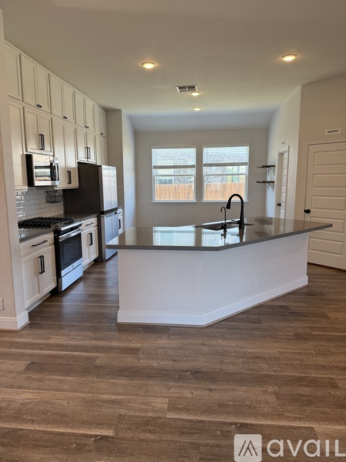 A kitchen with a black countertop and white cabinets.