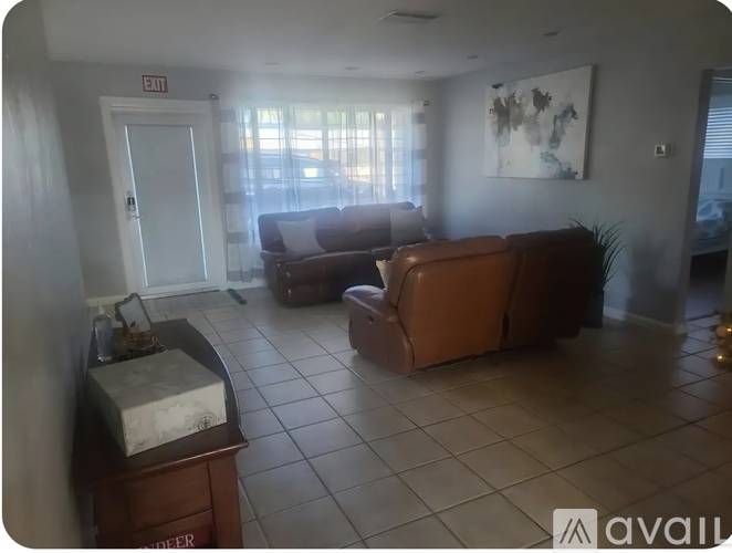 A living room with a brown couch and a wooden table.