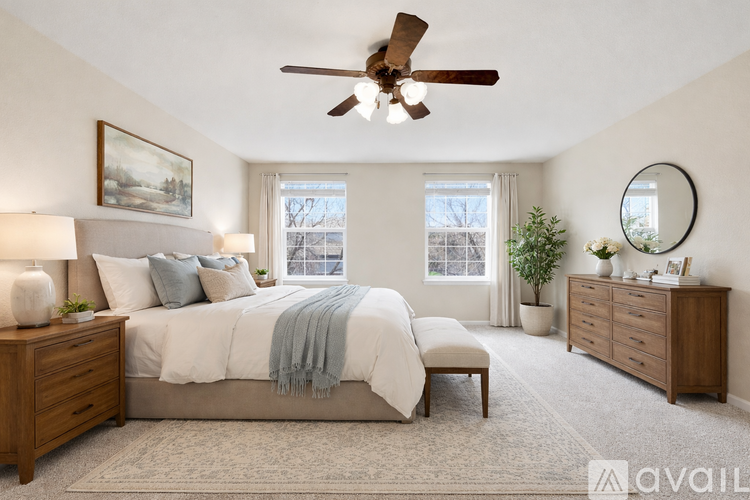A bedroom with a bed, a bench, a dresser, and a ceiling fan.