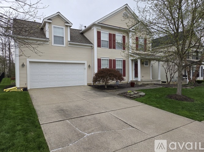 A two-story house with a garage and a driveway.