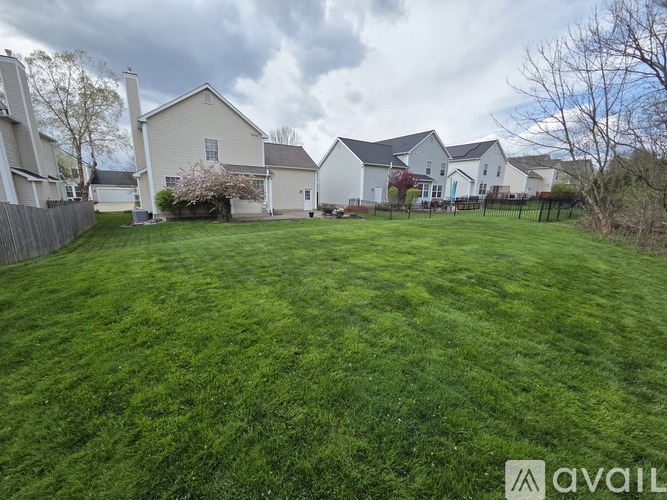A grassy yard with houses in the background.