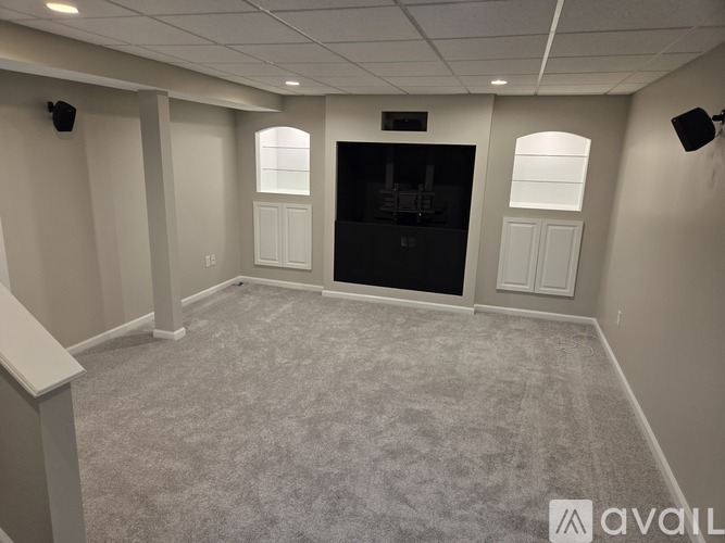 A spacious room with a carpeted floor and a fireplace.