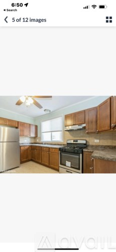 A kitchen with wooden cabinets and a stainless steel refrigerator.