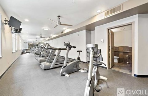 A gym with treadmills, exercise bikes, and a television.