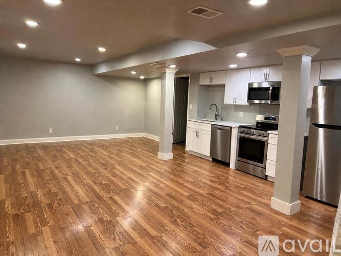 A kitchen with stainless steel appliances and wooden flooring.