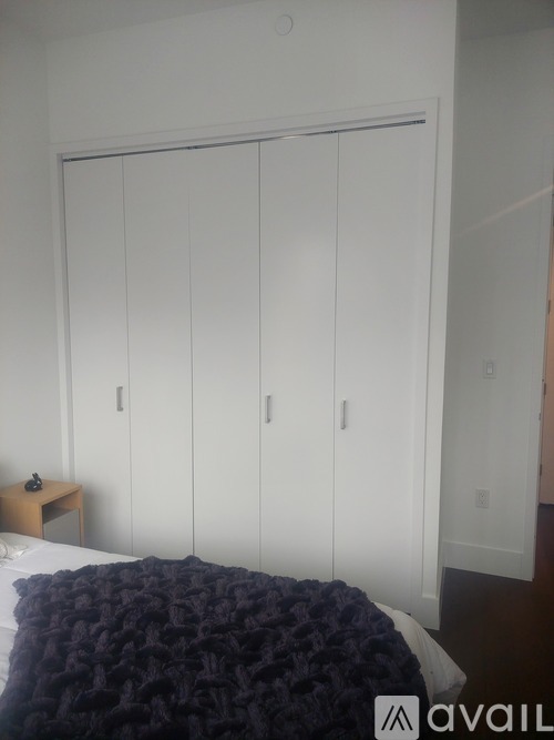 A bedroom with a bed, a nightstand and a wardrobe.