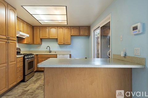 A kitchen with wooden cabinets and a stove top oven.