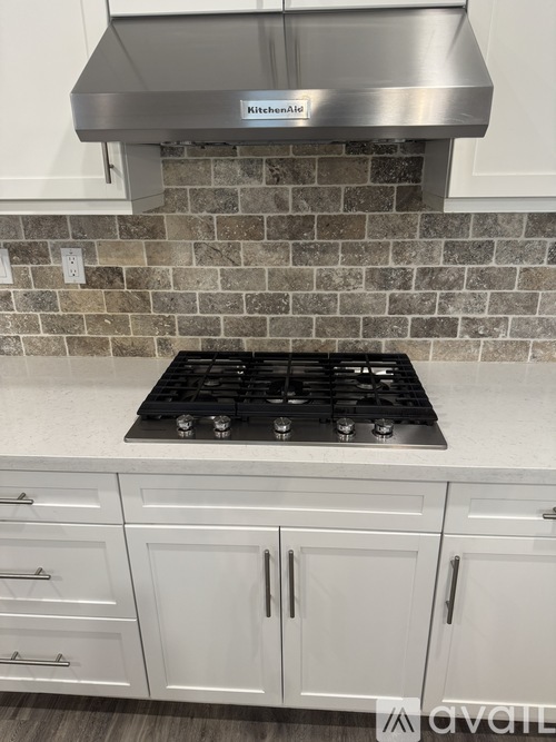A kitchen with a stove top and cabinets.