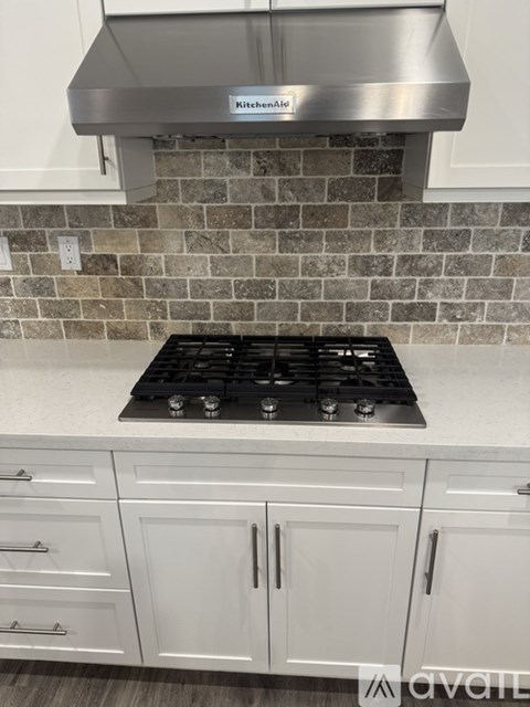 A kitchen with a stove top and cabinets.