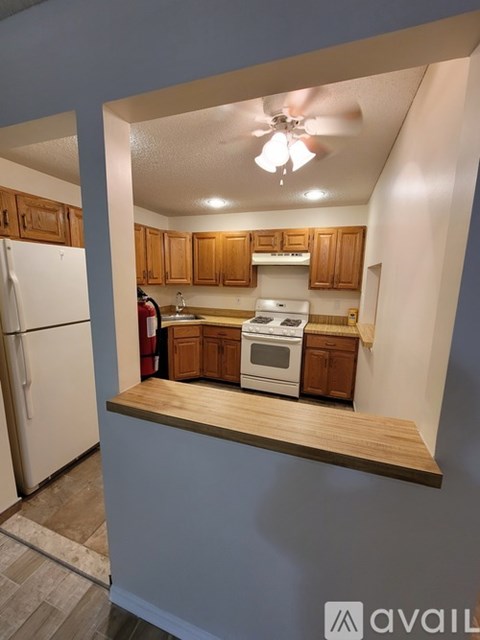A kitchen with wooden cabinets and a white refrigerator.