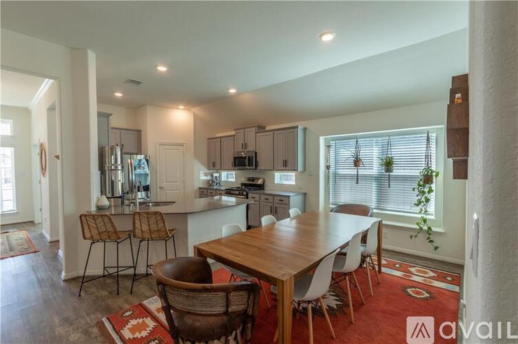 A kitchen with a dining table and chairs.