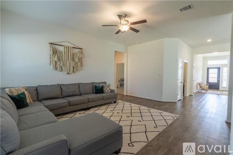 A living room with a grey sofa and a wooden floor.