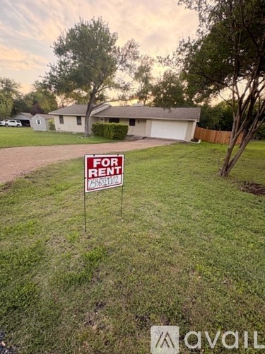 A house is for rent with a sign in the front yard.