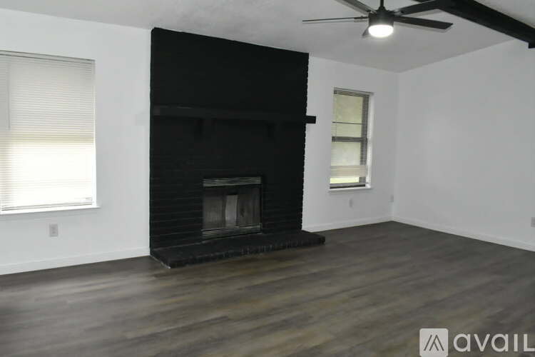 A room with a fireplace and a ceiling fan.