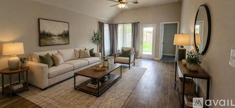 A living room with a white sofa, a coffee table, and a painting on the wall.