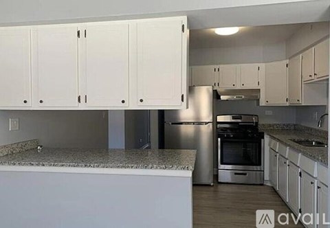 A kitchen with white cabinets and a granite countertop.