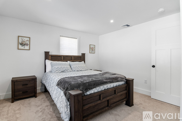 A bedroom with a large bed and a wooden nightstand.