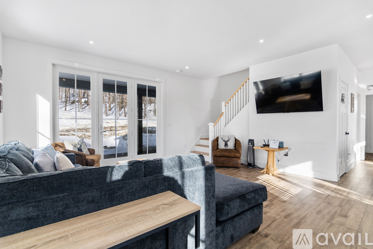 A living room with a grey couch and a wooden table.