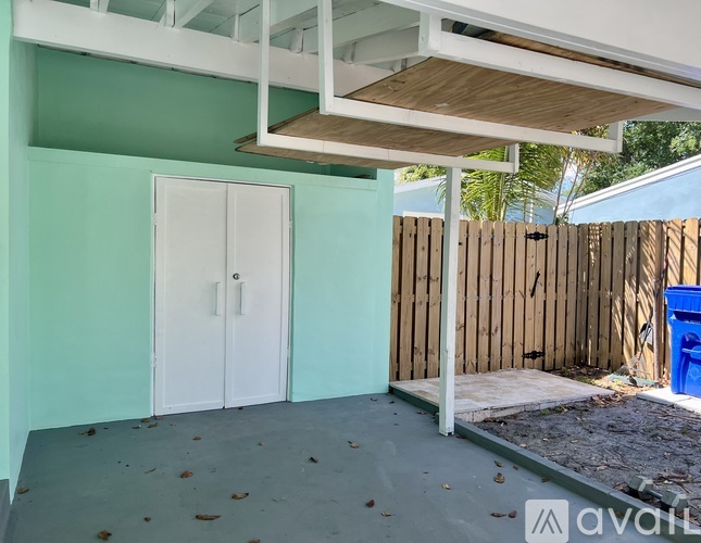 A room with a white door and a wooden fence outside.