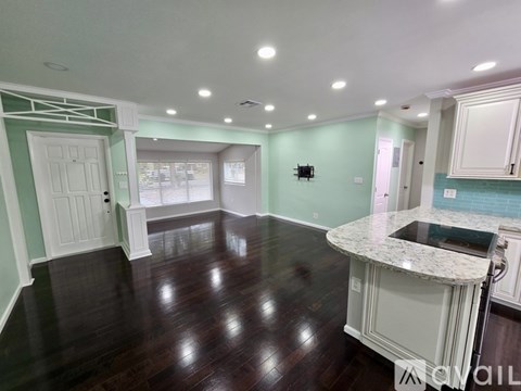A kitchen with a white counter and green walls.