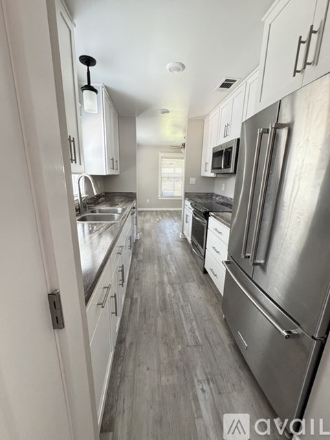 A kitchen with a refrigerator on the right.