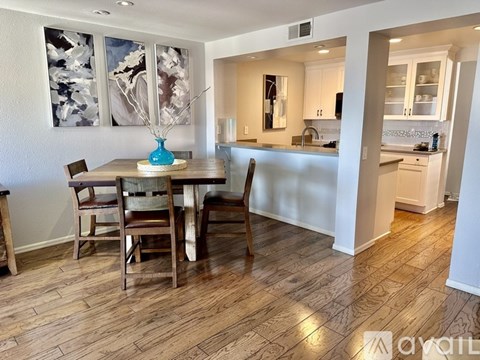 A dining room with a wooden table and chairs.