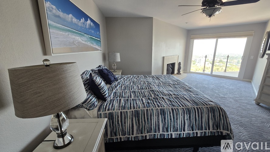 A bedroom with a bed, a lamp, and a ceiling fan.
