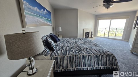 A bedroom with a bed, a lamp, and a ceiling fan.