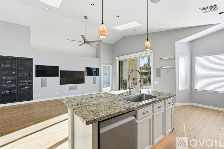 A kitchen with a granite countertop and a fan.