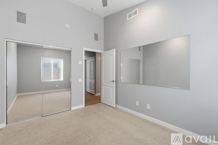 A bedroom with a mirror and a sliding glass door.