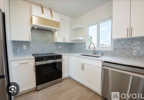 A kitchen with white cabinets and a stainless steel dishwasher.