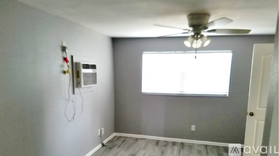 A room with a ceiling fan and a window.