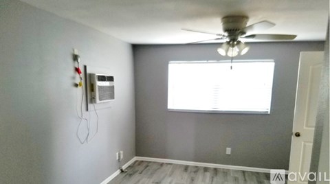 A room with a ceiling fan and a window.