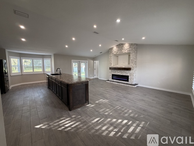 A spacious living room with a fireplace and a bar area.