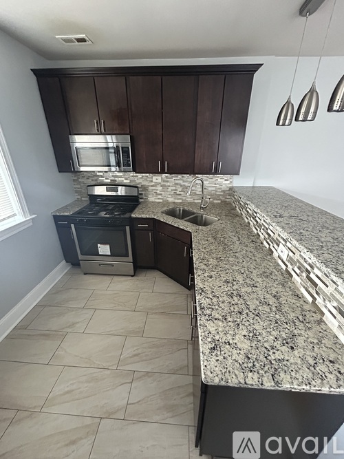 A kitchen with granite countertops and a stove top oven.